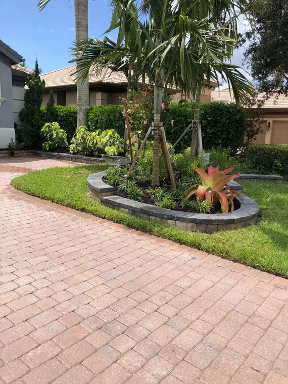 Circular warm-toned paver driveway and landscaped island