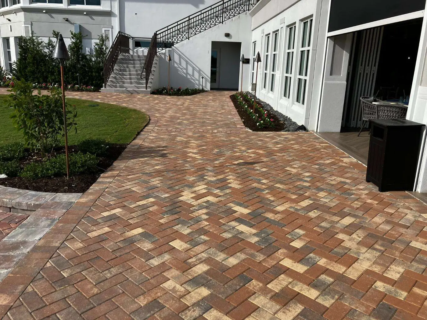 Completed brick paver patio flowing alongside a Florida residence